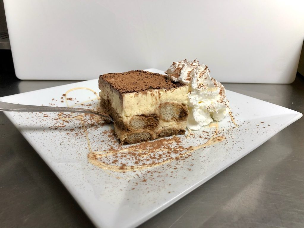 A slice of tiramisu with whipped cream at Tolli's Apizza